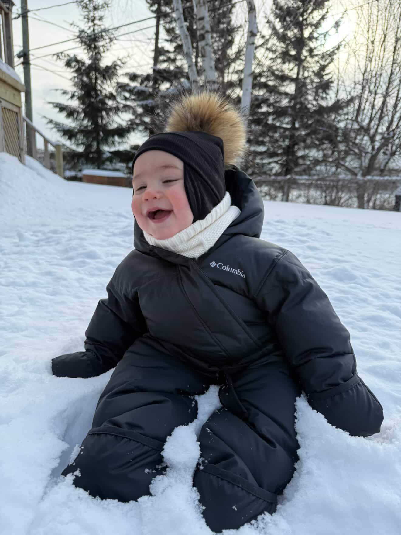 Tuque hiver bébé Kplla noire avec pompon portée dans la neige