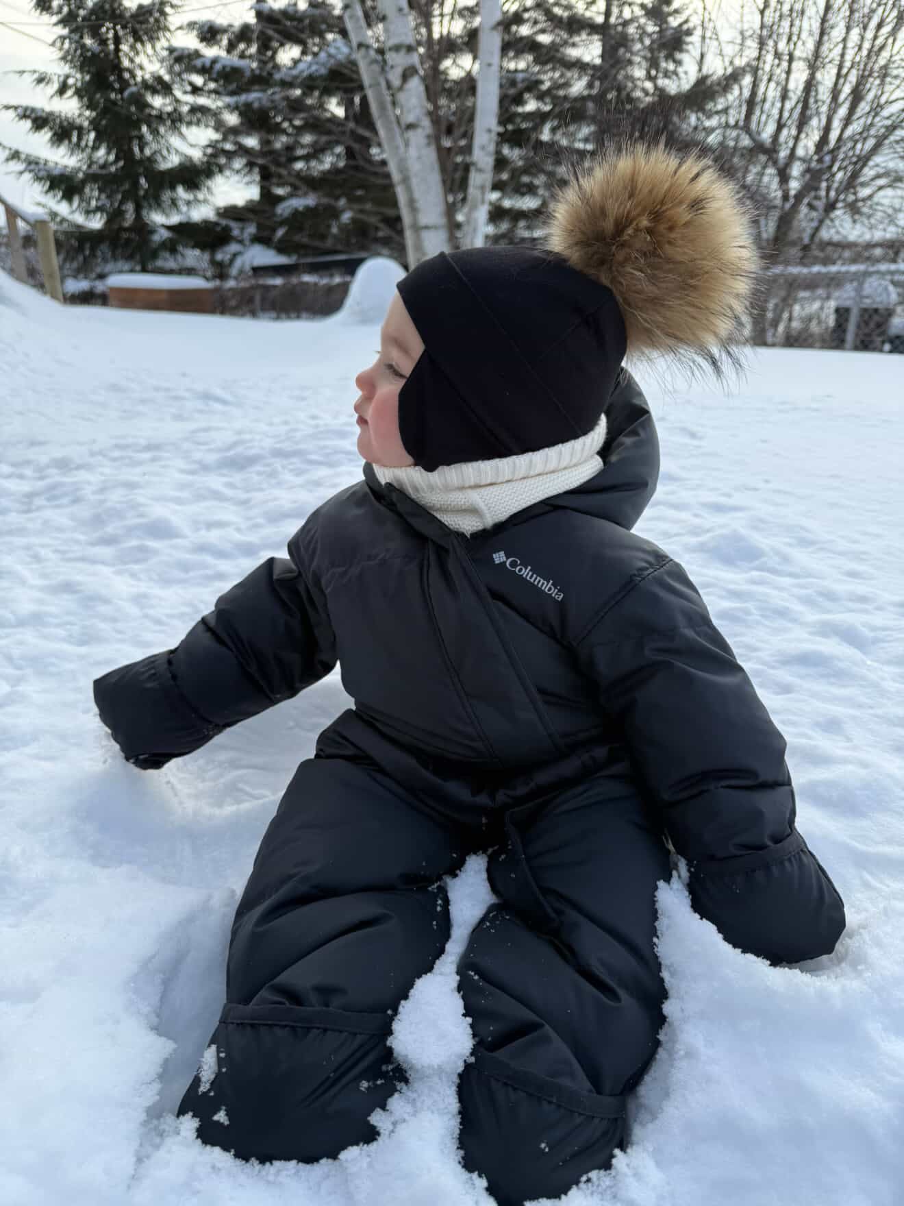 Tuque hiver bébé Kplla noire avec pompon portée dans la neige
